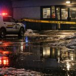 RCMP cruiser with flashing lights parked outside a commercial building in Thompson, Manitoba at night